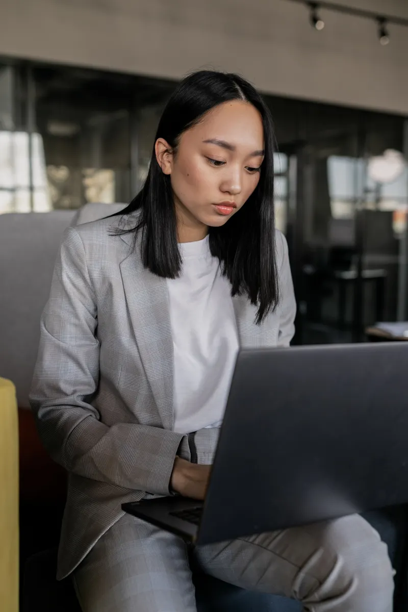 An operations professional working calmly at a laptop in a modern office
